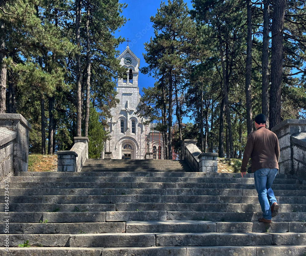 Obraz premium Tourist geht auf einer Treppe zur orthodoxen Kirche St. Vasilije von Ostrog in Nikšić, Montenegro