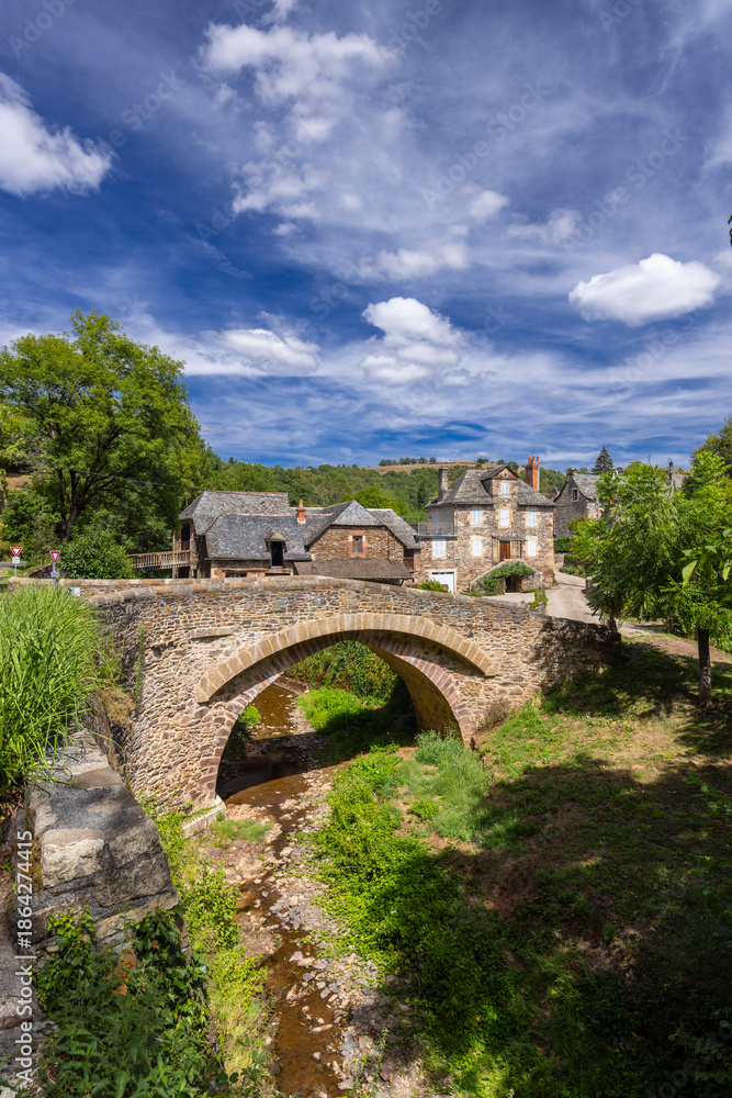 Fototapeta premium Stone arch bridge crossing a stream in Sebrazac village
