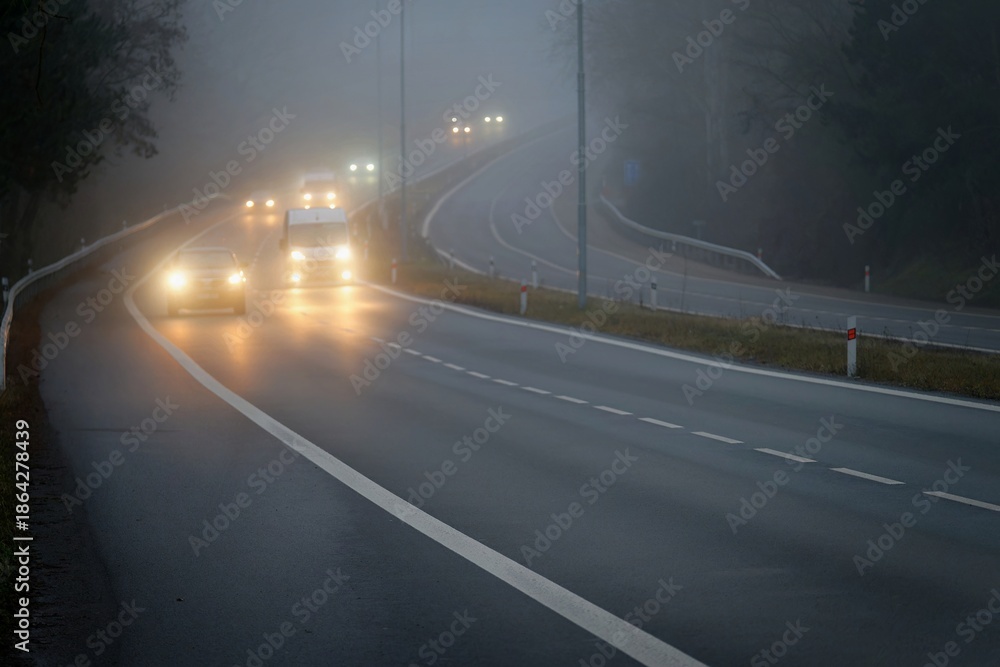 Fototapeta premium Bad weather driving - foggy hazy country road. Motorway - road traffic. Winter time