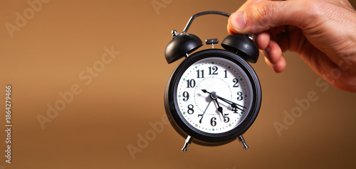 alarm clock in hand on white background