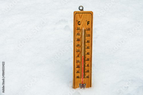 Thermometer in snow shows low temperatures. Low temperatures in degrees Celsius and fahrenheit. Cold winter weather