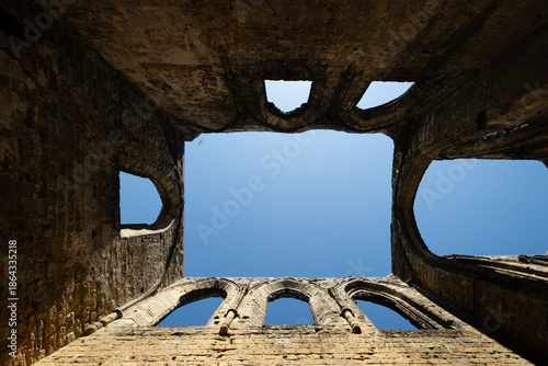Gothic arches framing blue sky in the sunlit ruins of Oybin Monastery, part of the castle complex on Oybin mountain in Saxony, Germany