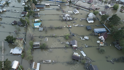 Aerial drone footage of a massive city flood with houses and streets submerged under water. Urban flooding caused by extreme weather and heavy rainfall, showing natural disaster impact on residential 