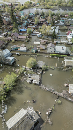 Aerial drone footage of a massive city flood with houses and streets submerged under water. Urban flooding caused by extreme weather and heavy rainfall, showing natural disaster impact on residential 