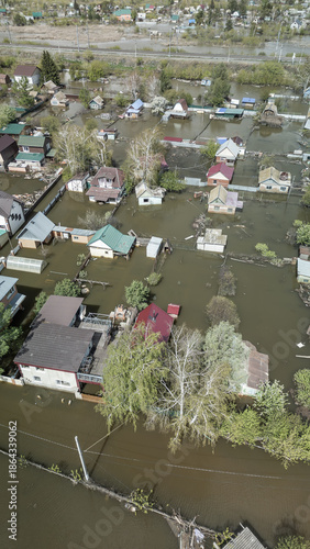 Aerial drone footage of a massive city flood with houses and streets submerged under water. Urban flooding caused by extreme weather and heavy rainfall, showing natural disaster impact on residential 