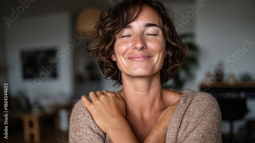 Mature woman with eyes closed hugging herself i