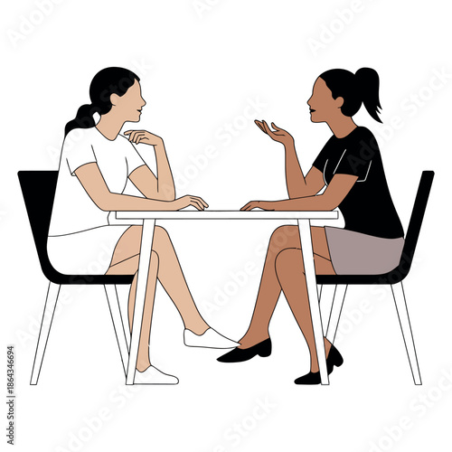 Two diverse women sit opposite each other at a minimalist table engaged in conversation.