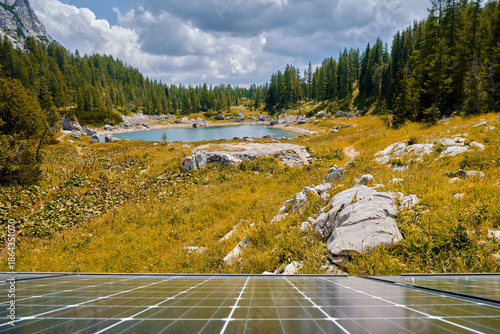 Scenic lake on Triglav mountain in Slovenia, autumn colored grass and foreground solar panels from the mountain hut