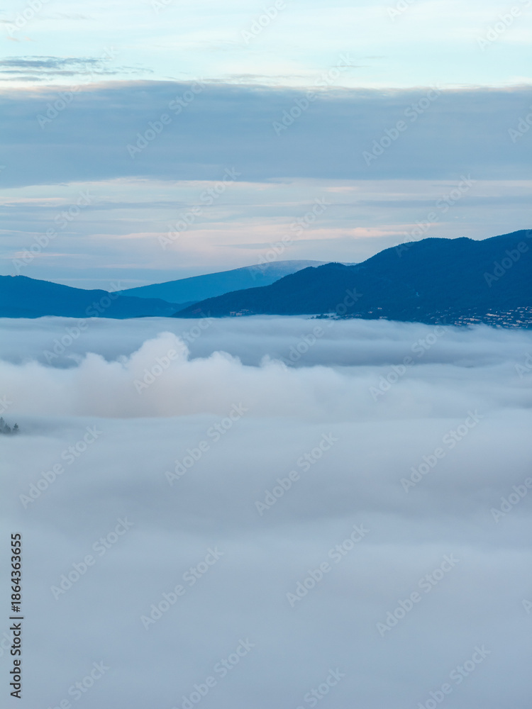 Fototapeta premium Serene Mountain Range Above Cloud Sea in Morning Mist Over Burnaby, Greater Vancouver