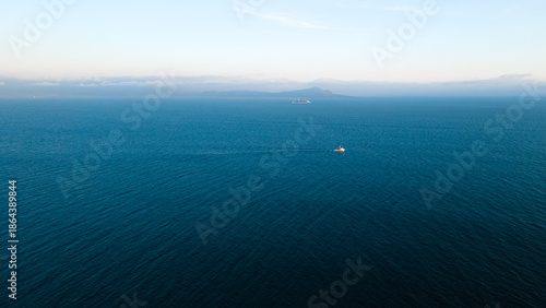Εκτύπωση καμβά Minimal open ocean with small boat and distant horizon