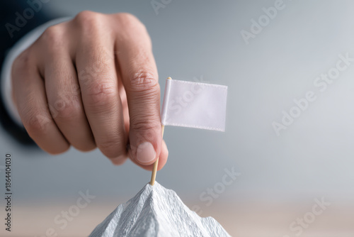 White flag hand finger mountain peak achievement person small flag close up minimal