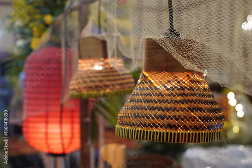Traditional Indonesian-style pendant lights made of woven bamboo with a warm glow, decorated with fishing nets for a rustic or ethnic-themed event interior