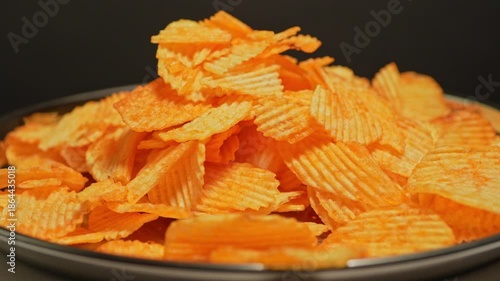 Crispy golden potato chips are falling slow motion. Fast food and junk food. Unhealthy food with high calories, unhealthy fats, salt, and chemical byproducts. Ultra processed snack. High health risks