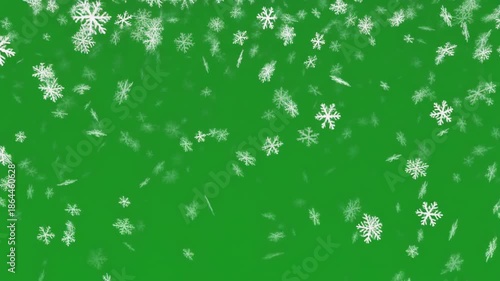 Snowflakes gently falling against a vibrant green background