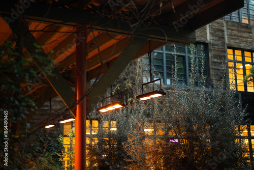 Quadro su tela Outdoor cafe equipped with infrared heaters suspended from ceiling to comfortably warm visitors during cold season