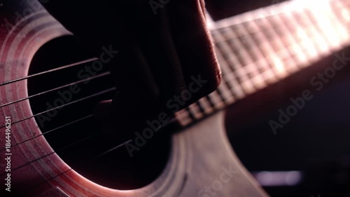 Artistic close up of hands strumming an acoustic wooden guitar under warm cinematic lighting, representing passion for music and soulful creativity