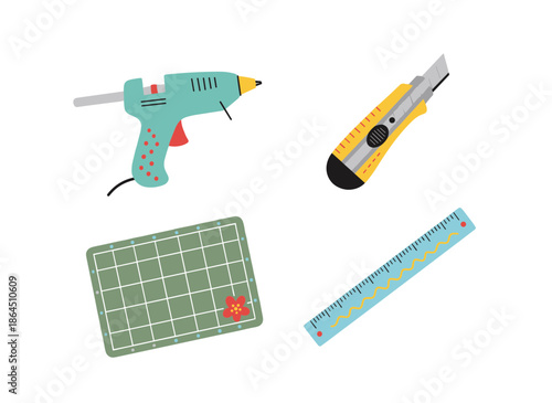 Handheld craft and DIY tools set featuring hot glue gun yellow utility cutter knife green cutting mat and blue ruler for creative projects