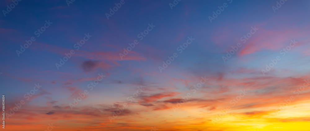 Fototapeta premium Vibrant sunset sky with colorful clouds and blue twilight gradient background