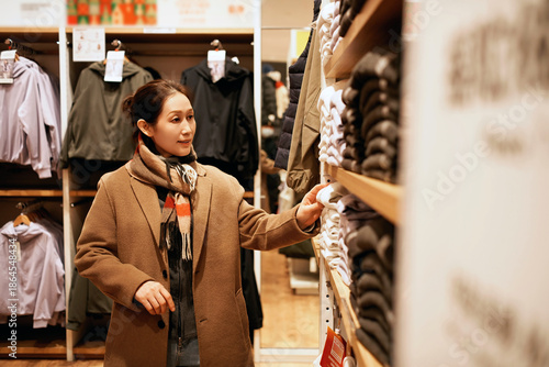 Photos Woman Shopping for Outerwear in Clothing Store