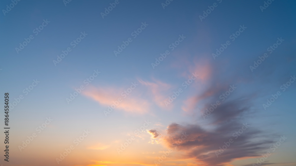 Fototapeta premium Dusk Sky with Fluffy Clouds and Warm Sunset