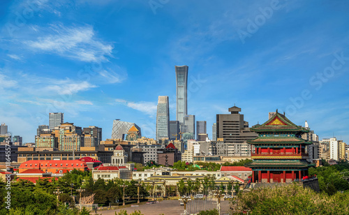 City skyline of Beijing featuring historic Zhengyangmen Gate and modern CITIC Tower under clear blue sky.