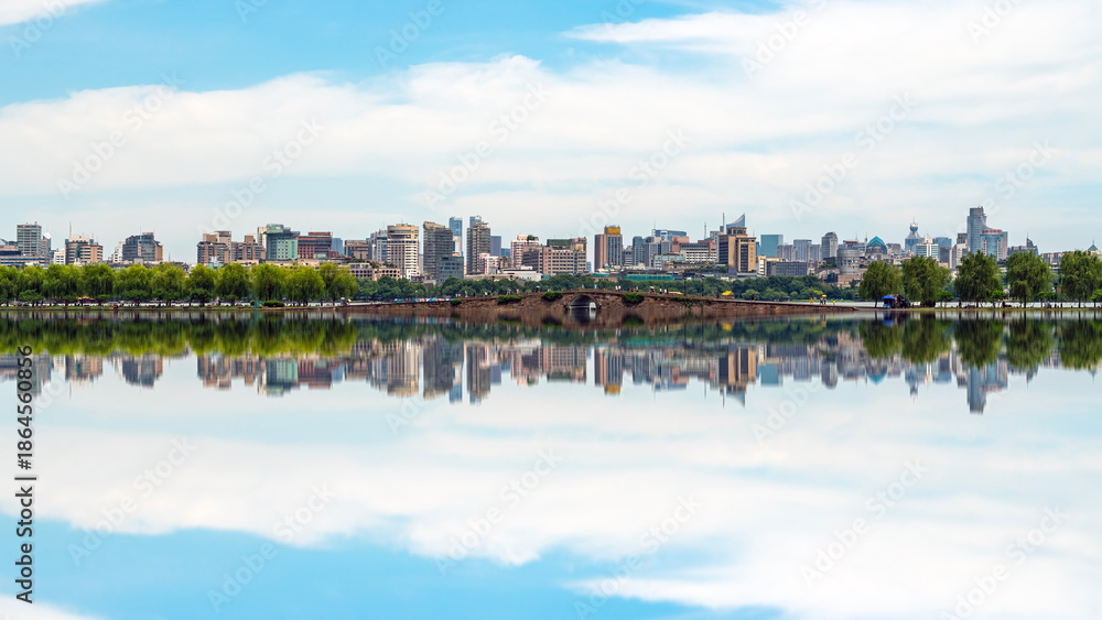 Fototapeta premium Urban Skyline Reflected in Calm Lake Water