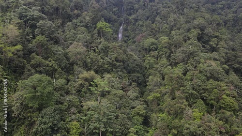 Beautiful waterfall in the middle of forest. Sanya waterfall, Indonesia. Aerial nature scenery from above