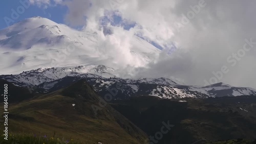panoramic view of the majestic, snow-covered, two-peaked dormant volcano, Mount Elbrus, the highest peak in Europe, as seen from Mount Cheget in the Kabardino-Balkaria Republic, Russia. The vast mount