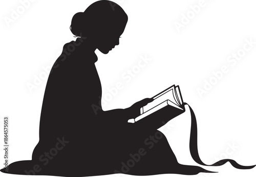 Silhouette of a person reading a book on the ground