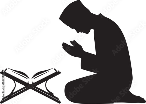 Silhouette of person praying with open book on stand
