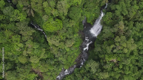 Beautiful waterfall in the middle of forest. Sanya waterfall, Indonesia. Aerial nature scenery from above