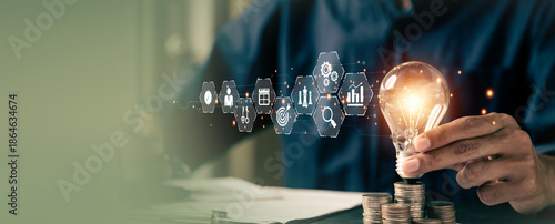 Businessman's hand chooses light bulb or lamp with bright and business icons for human resources or leadership and creativity thinking idea motivation or vision and knowledge learning.