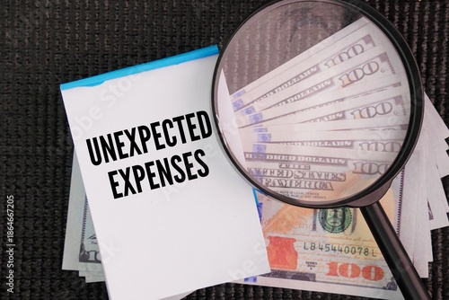 Fotografia Magnifying glass, banknotes and paper with the words Unexpected expenses