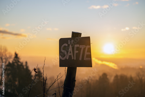 Selbstgeschriebenes Schild an einem Weinberg im Sonnenaufgang im Winter preist selbstgemachte, hausgemachte Säfte an, Hofverkauf