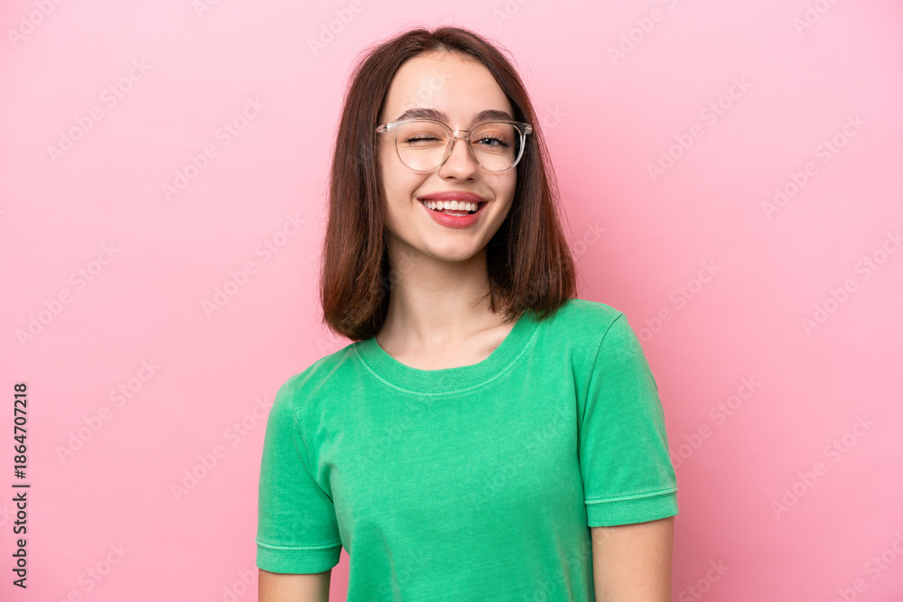 Fototapeta premium Young Ukrainian woman isolated on pink background With glasses and happy expression