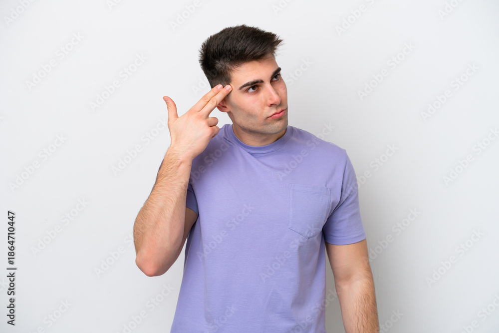 Fototapeta premium Young caucasian man isolated on white background with problems making suicide gesture