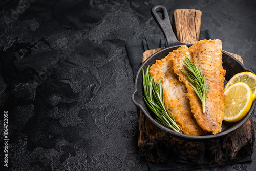 Φωτογραφία Pan Fried Hake white fish fillet. black background. top view