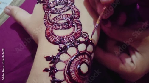 Intricate henna design being applied to a hand showcasing detailed patterns and artistic craftsmanship in progress