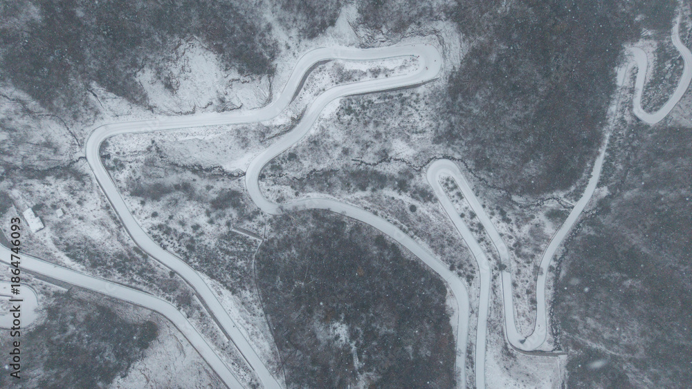 Obraz premium The winding mountain road covered in heavy snow