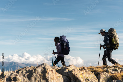 Adventurous trekkers moving steadily along high mountain skyline