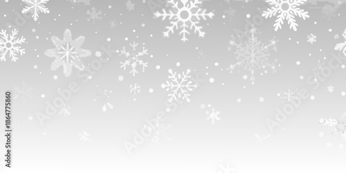 Delicate snowflakes falling against a soft gray winter background