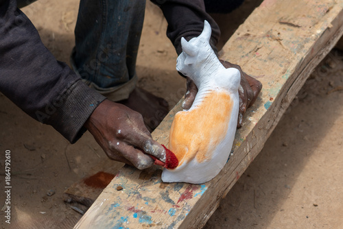 Fotografi Madagascar, Working hands shape figures from clay.