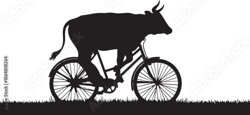 Black silhouette of a cow riding a bicycle on grass