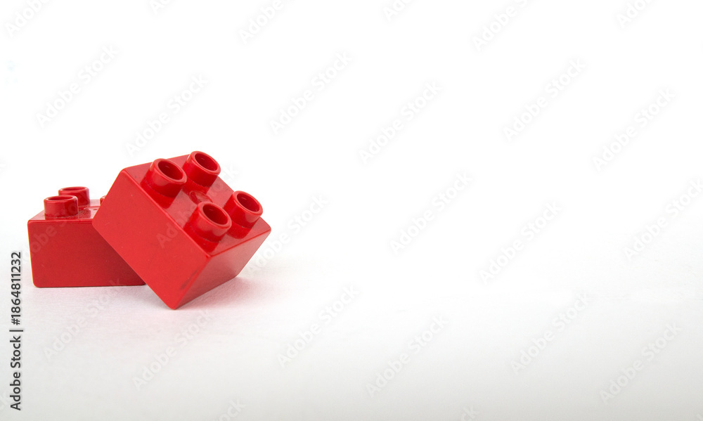 Fototapeta premium Piezas rojas de LEGO DUPLO con fondo blanco. Marco, espacio para texto
