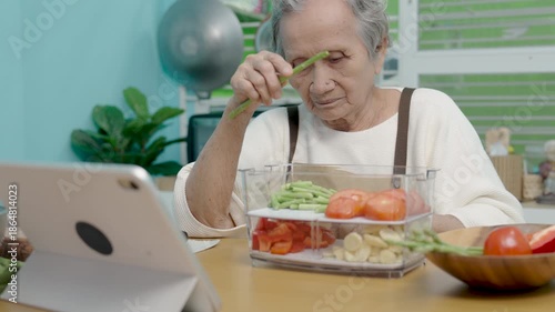 Seniors woman are cooking in their home kitchen and looking at digital tablets to learn how to cook.