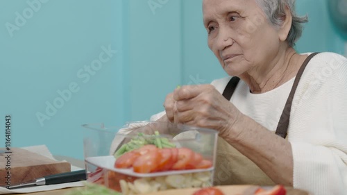 Seniors woman are cooking in their home kitchen and looking at digital tablets to learn how to cook.