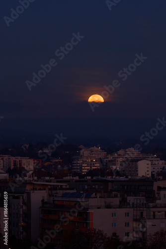 orange full moon setting on a skyline