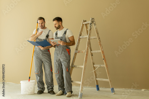 Two workers discuss plans w...