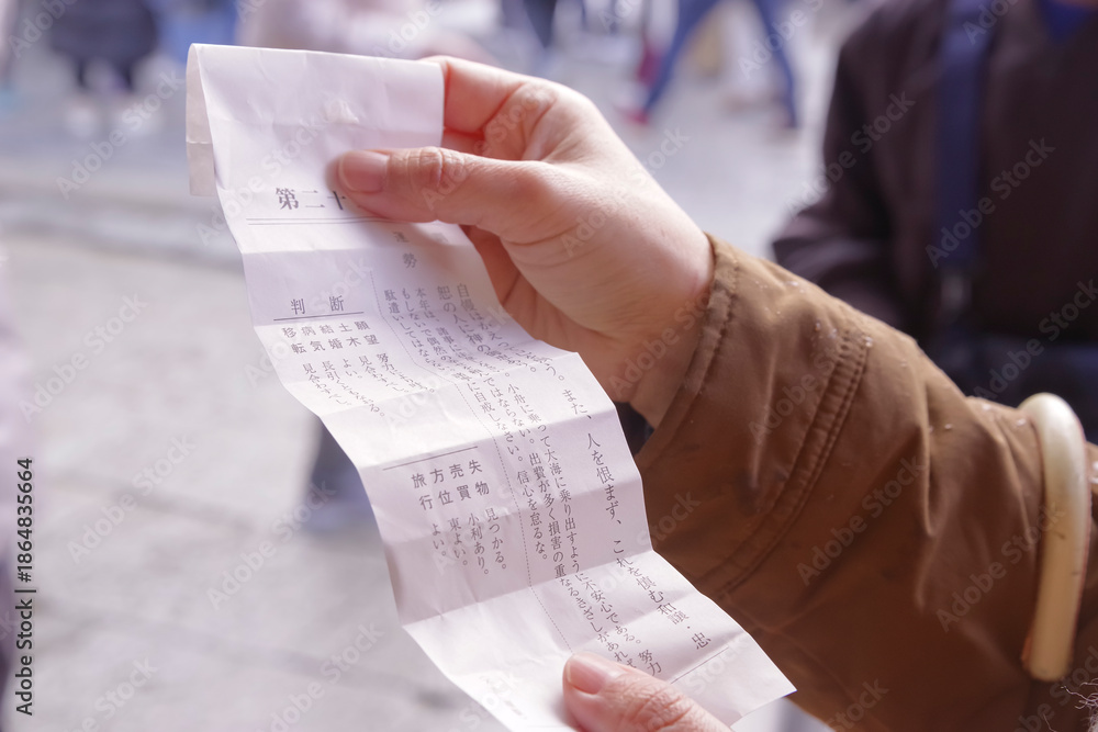 Naklejka premium 神社のおみくじで運勢を占う女性の手元