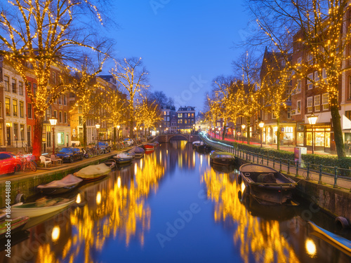 Photography Iconic Amsterdam city landscape during winter holidays with beautiful Christmas decorations, evening illumination, and traditional Dutch architecture